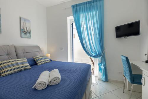 Un dormitorio con una cama azul con toallas. en Casa Borgo Sant'Angelo, en Isquia