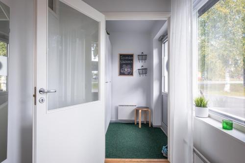 a hallway with a white door and a green carpet at Tuurin Kukkis in Tuuri