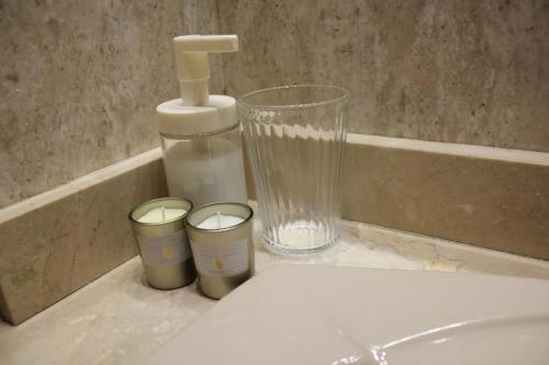 a bathroom sink with a faucet and two cups at APARTAMENTO BARAJAS-IFEMA in Madrid