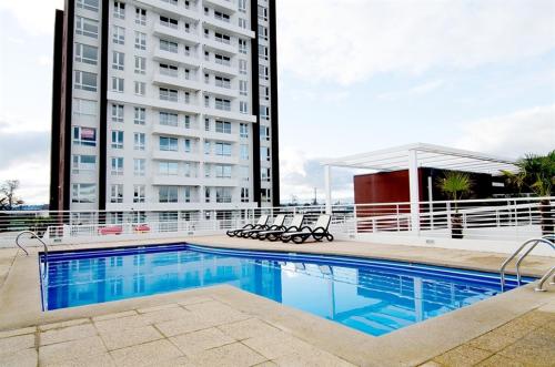 a swimming pool in front of a tall building at Departamento Ipanema in Temuco
