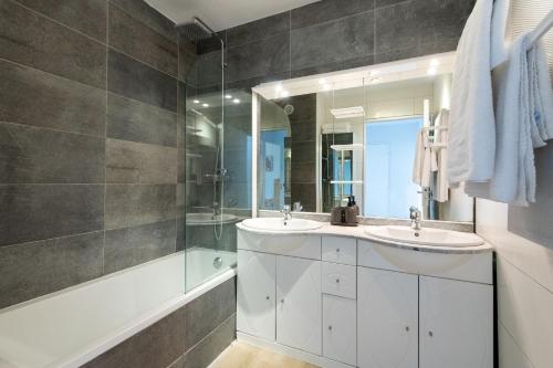 La salle de bains est pourvue de 2 lavabos, d'une douche et d'une baignoire. dans l'établissement Happyfew Le Flora, à Nice