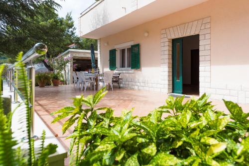 a house with a patio with a table and chairs at Apartments Remini in Grebaštica