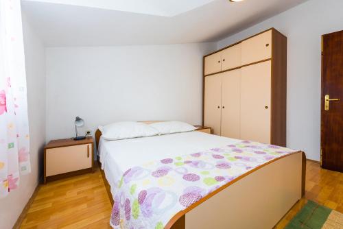 a bedroom with a bed and a dresser at Apartments Remini in Grebaštica