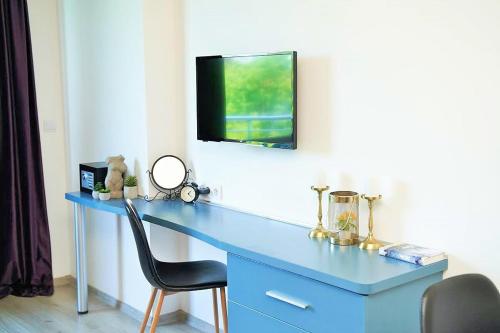 a blue desk with a television on a wall at Design Studio in Atlantis Resort&SPA, Burgas Airport in Burgas City