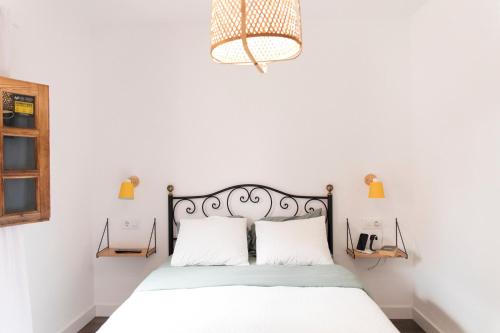 - une chambre blanche avec un lit et deux oreillers dans l'établissement Acogedor apartamento en San Andrés - Casa La Traiña, à San Andrés