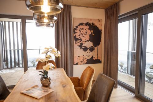 a dining room with a table and chairs and a large window at Weitenmoos Panorama Apart & Rooms in Sankt Johann im Pongau