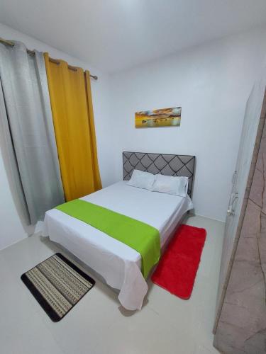 a bedroom with a bed with a green and yellow blanket at Soleil couchant by Oasis Holidays in Rivière Noire