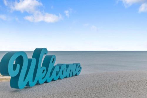 a sign on the beach with the ocean in the background at Ocean Front 2BR Elegant Condo in Atlantica Resort in Myrtle Beach