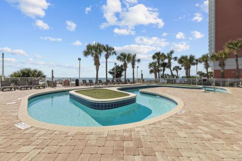 a small swimming pool with palm trees and the ocean at Ocean Front 2BR Elegant Condo in Atlantica Resort in Myrtle Beach