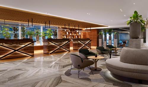 a lobby of a hotel with chairs and tables at Sheraton Amsterdam Airport Hotel and Conference Center in Schiphol