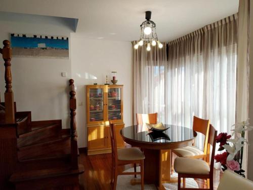a dining room with a table and chairs and a chandelier at HHC - Duplex Concheiros, 4 bedrooms, 3 bathroom, a 700m de la Catedral in Santiago de Compostela