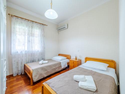 sypialnia z 2 łóżkami i oknem w obiekcie Aleka's House in Corfu Town w Korfu