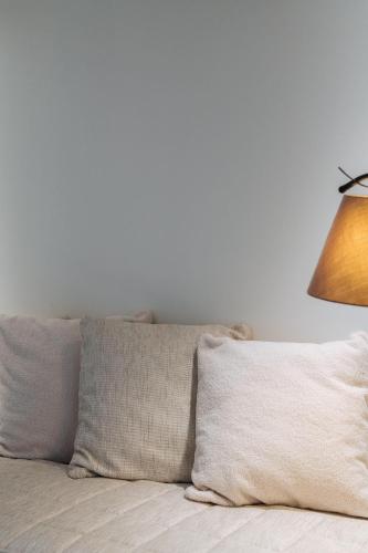 a bed with two pillows and a lamp on it at Cosmopolite Hotel Nieuwpoort-Bad in Nieuwpoort