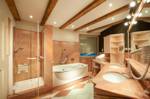 a bathroom with a tub and a shower and a sink at Residence Adler in Villabassa