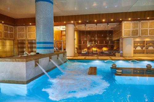 a large pool with a water slide in a hotel at Divani Apollon Palace & Thalasso in Athens