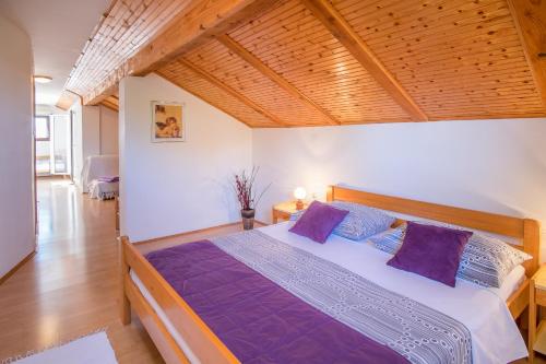 a bedroom with a large bed with purple pillows at Apartments Durda in Krk