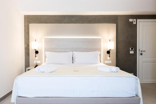 sypialnia z dużym białym łóżkiem z 2 białymi poduszkami w obiekcie Hotel La Principessa w mieście Campora San Giovanni