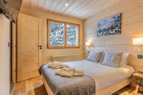 ein Schlafzimmer mit einem Bett mit zwei Handtüchern darauf in der Unterkunft Apartment Les Cerfs in Megève