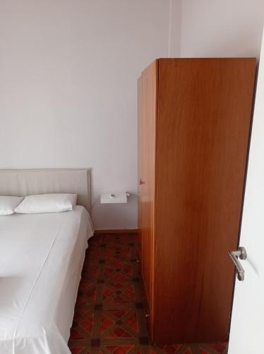 a bedroom with a bed and a wooden door at Giorgos house in Nea Kalikratia