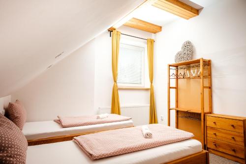 sypialnia z 2 łóżkami i oknem w obiekcie Pension U Blinků w mieście Dolní Bečva