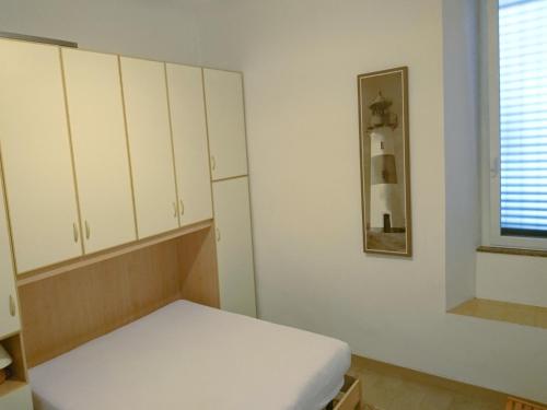 une chambre avec un lit, des armoires et une fenêtre dans l'établissement Grottammare mon amour Ponente, à Grottammare