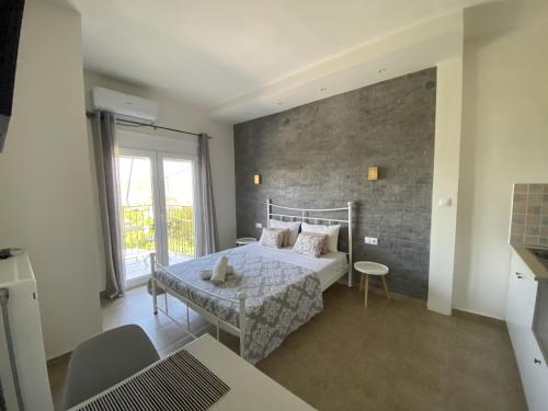 - une chambre avec un lit et un mur en briques dans l'établissement Ai Nies Studios, à Soúrpi