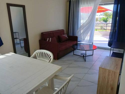 a living room with a red couch and a table at Villa de vacances privative in Toamasina