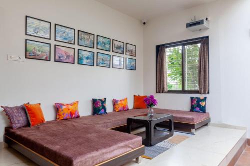 a living room with a couch and a table at Lakeside Summers by VEO - Part of StayVista in Trimbak