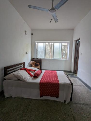 a bedroom with a bed with a red blanket on it at Shiranthi Guest House in Rajagiriya
