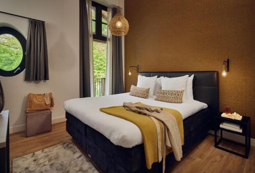 a hotel room with a bed with a blanket on it at Boutique Hotel Beekhuizen in Velp