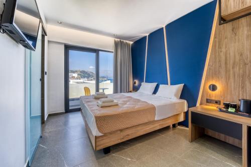 1 dormitorio con 1 cama grande y pared azul en Island Sea Side Hotel - Adults Only, en Rodas