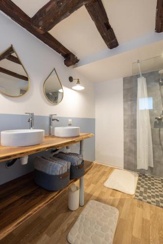 une salle de bain avec un lavabo et deux miroirs dans l'établissement Gite Pomme de Reinette, à Urschenheim
