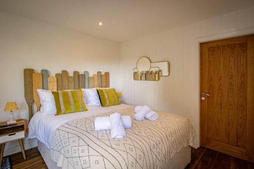 a bedroom with a bed with towels on it at Lake District Woodland Pods - Winster, Bowness-on-Windermere in Winster
