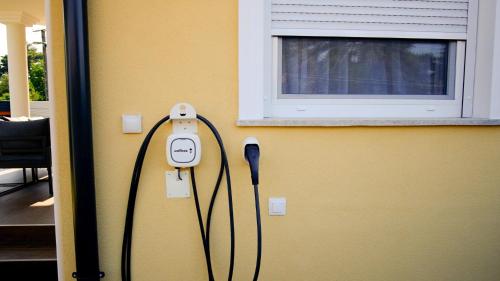 a room with a phone plugged into a wall at LuxVil Apartman in Balatonkeresztúr