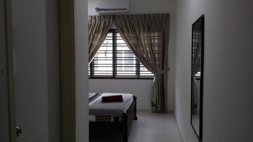 1 dormitorio con ventana y 1 cama en una habitación en Cosy Spacious Homestay in Central Batu Pahat with Wifi & GENTING Clubhouse, en Kampong Sri Gading