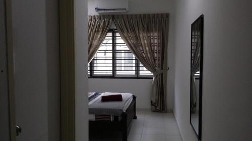 a bedroom with a window and a bed in a room at Cosy Spacious Homestay in Central Batu Pahat with Wifi & GENTING Clubhouse in Kampong Seri Gading