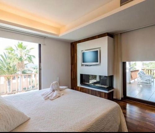 una camera con letto e TV a schermo piatto di Villa Elena a San Jose de sa Talaia