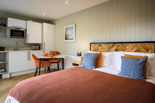 a bedroom with a bed and a kitchen with a table at Comfy Lake District Cabins - Winster, Bowness-on-Windermere in Winster