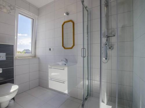 uma casa de banho com um chuveiro, um lavatório e um WC. em Pokoje gościnne Kolc em Jastarnia