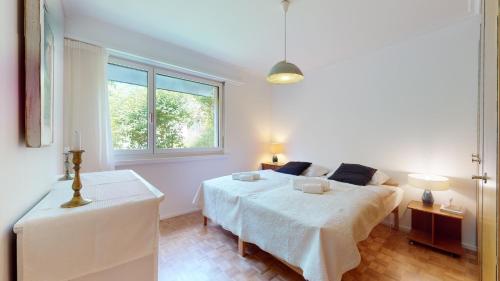 Un pat sau paturi într-o cameră la Bright flat overlooking Lake Geneva