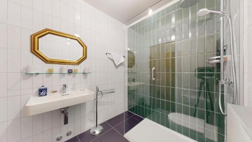 een badkamer met een douche, een wastafel en een spiegel bij Bright flat overlooking Lake Geneva in Montreux