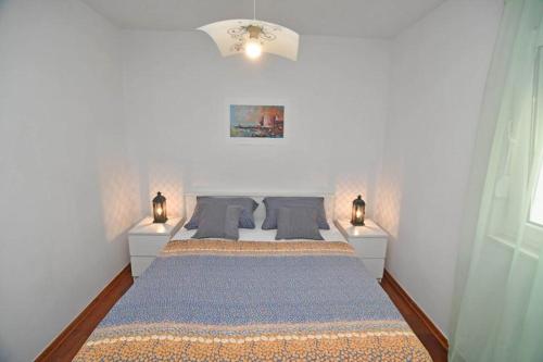 杜布羅夫尼克的住宿－Verica house，一间卧室配有一张大床和两盏灯