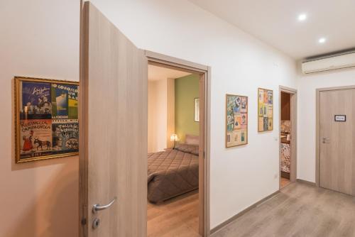 Una puerta a un dormitorio con una cama en una habitación en Accasatua Neapolitan Apartments en Nápoles