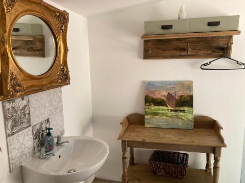 y baño con lavabo y espejo. en Outstandingly situated cosy Shepherds Hut, en Longhope