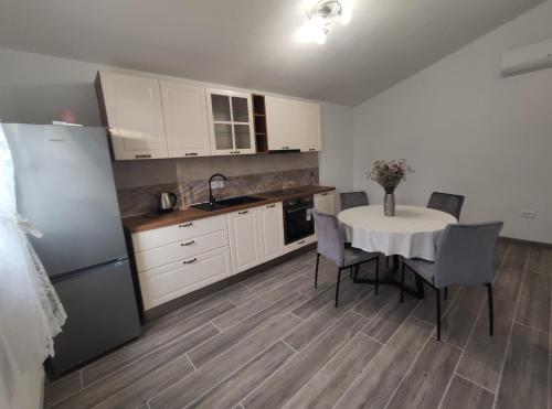 a kitchen with a table with chairs and a refrigerator at Apartmani Lešić Zaklopatica in Lastovo