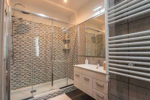a bathroom with a glass shower and a sink at Accasatua Neapolitan Apartments in Naples