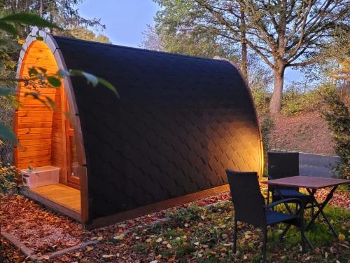a tiny house with a black roof and a table at Pods Alte Schule in Elchweiler