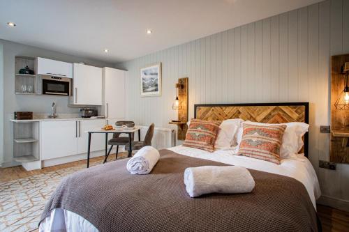 WinsterLake District Woodland Pods - Winster, Bowness-on-Windermere的一间带大床的卧室和一间厨房