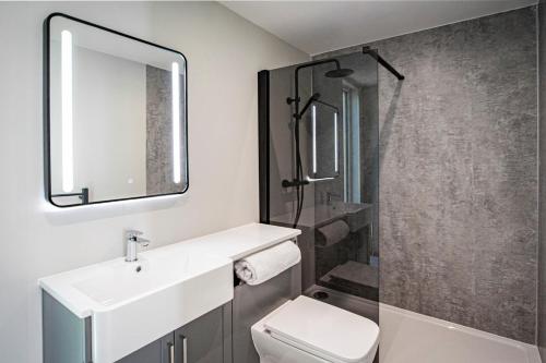 a bathroom with a toilet and a sink and a shower at Lake District Woodland Pods - Winster, Bowness-on-Windermere in Winster