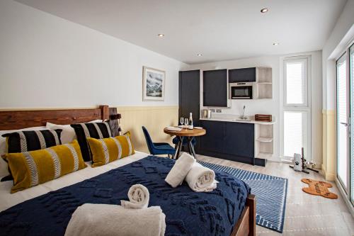 a bedroom with a large bed with towels on it at Lake District Woodland Pods - Winster, Bowness-on-Windermere in Winster